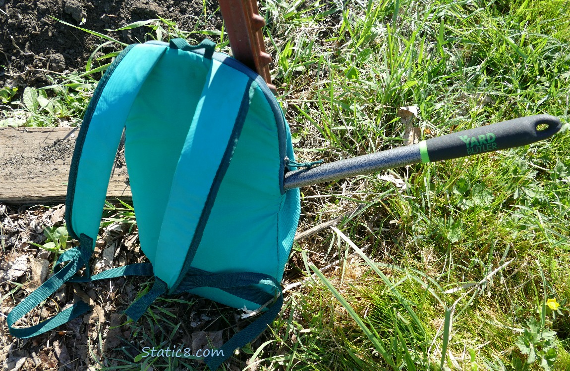 green back pack on the ground with a handle sticking out the side