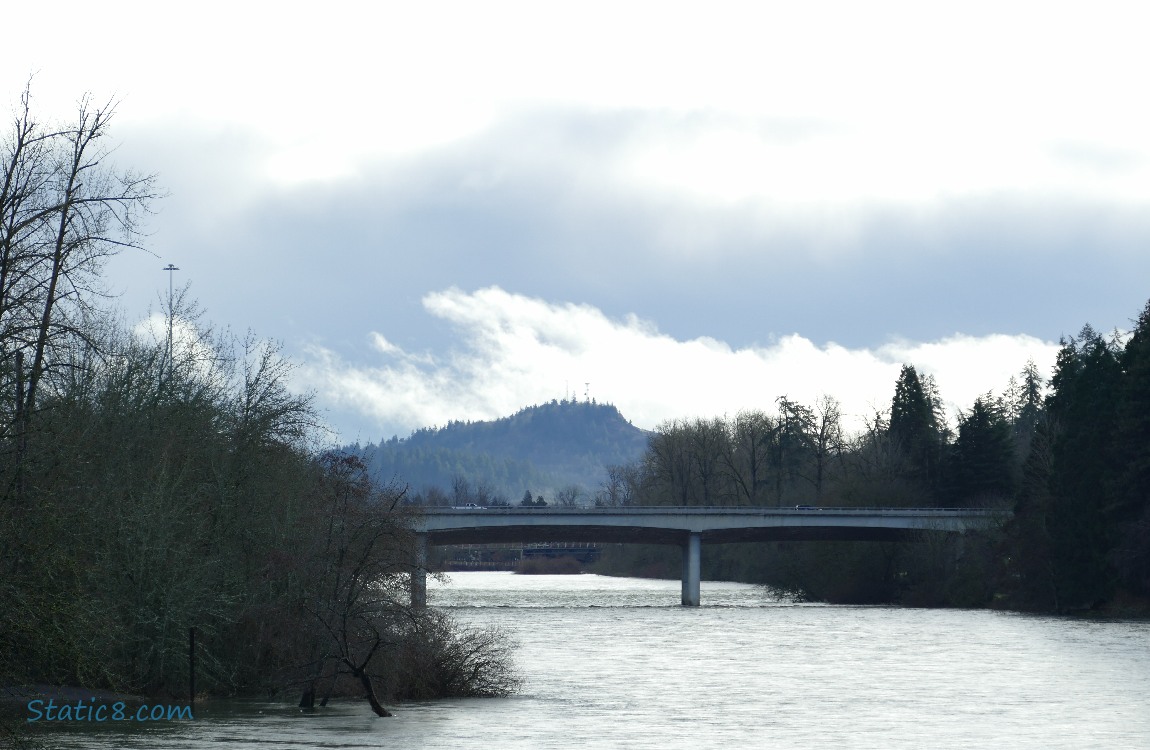 clouds over the hill and car bridge over the river