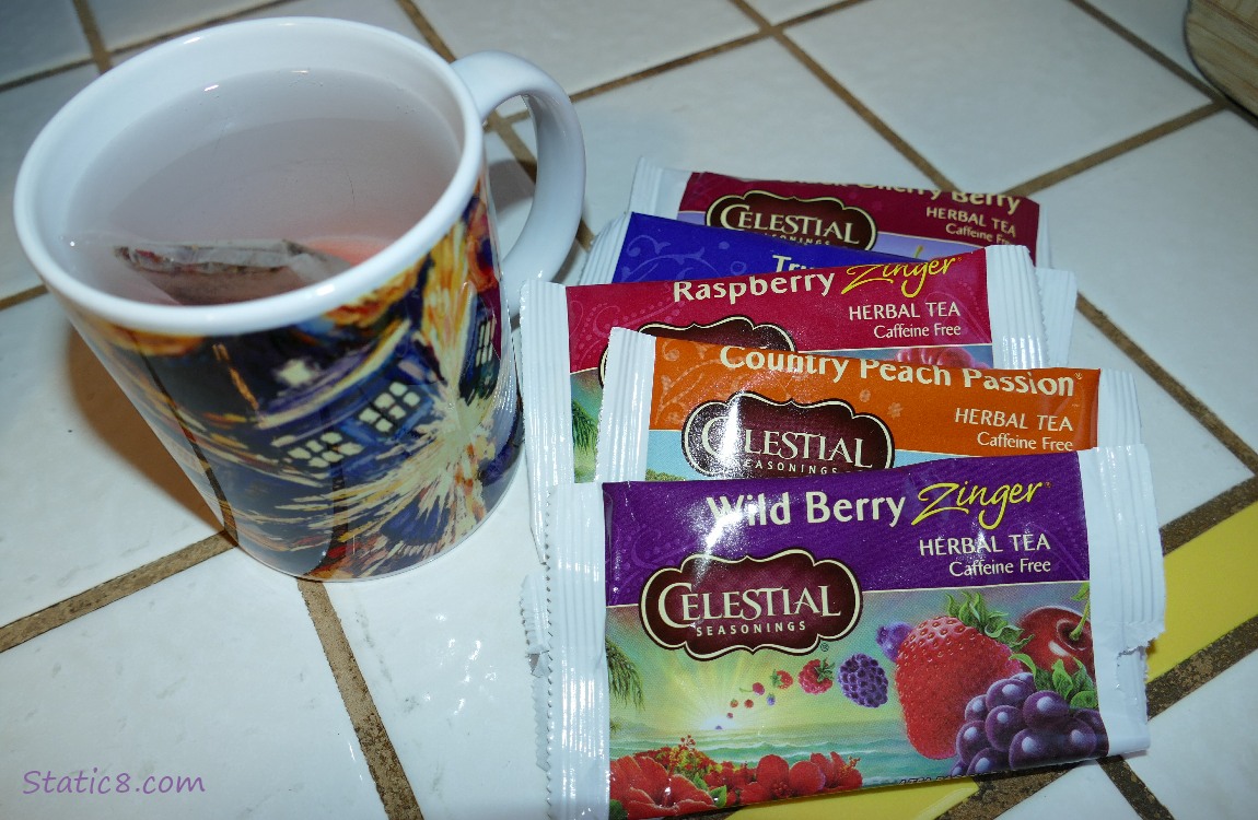 Packets of Herbal Teas next to a mug of water with a tea bag in it!