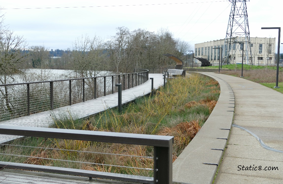 Board walk next to the river, building in the background