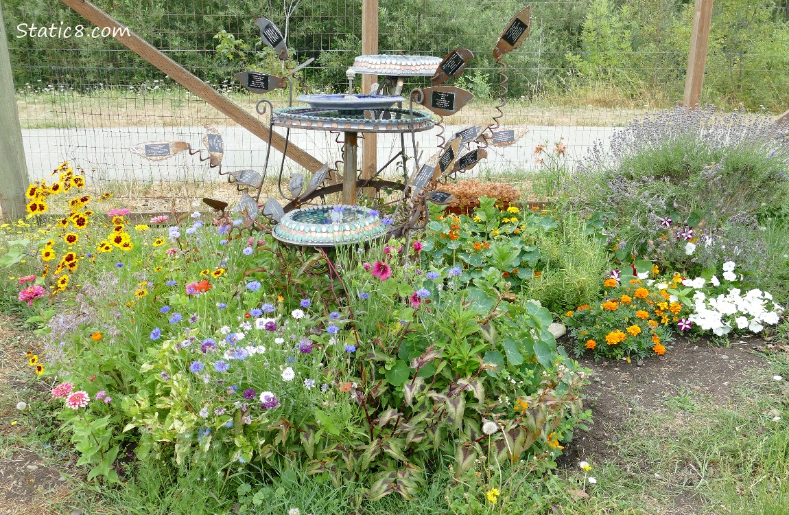 Flowers around an artsy bird bath