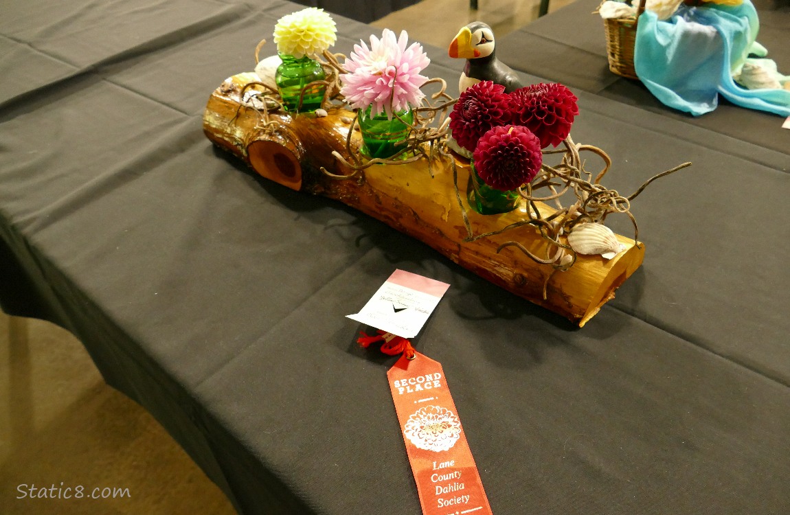 Dahlia flower arrangement with a Puffin statue