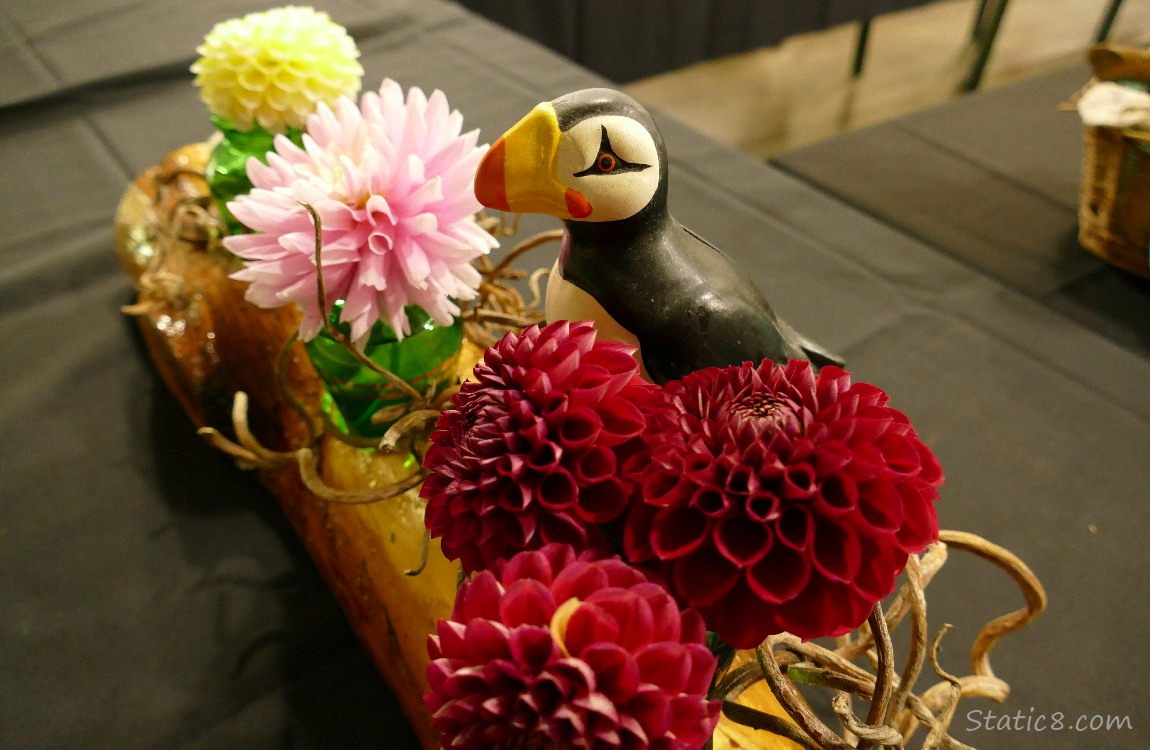 Dahlia flower arrangement with a Puffin statue