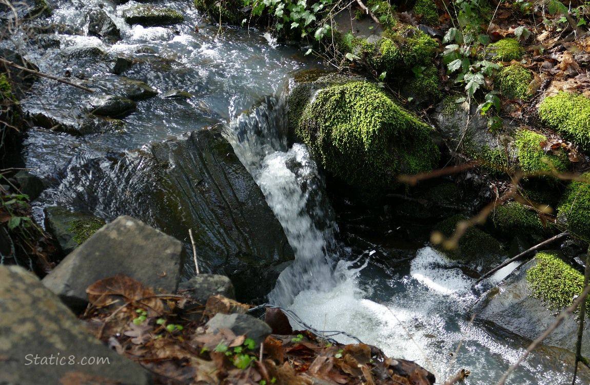 water falling past mossy rocks