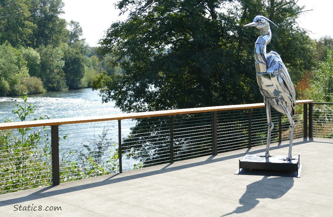 Sculpture of a Great Blue Heron with the river in the background