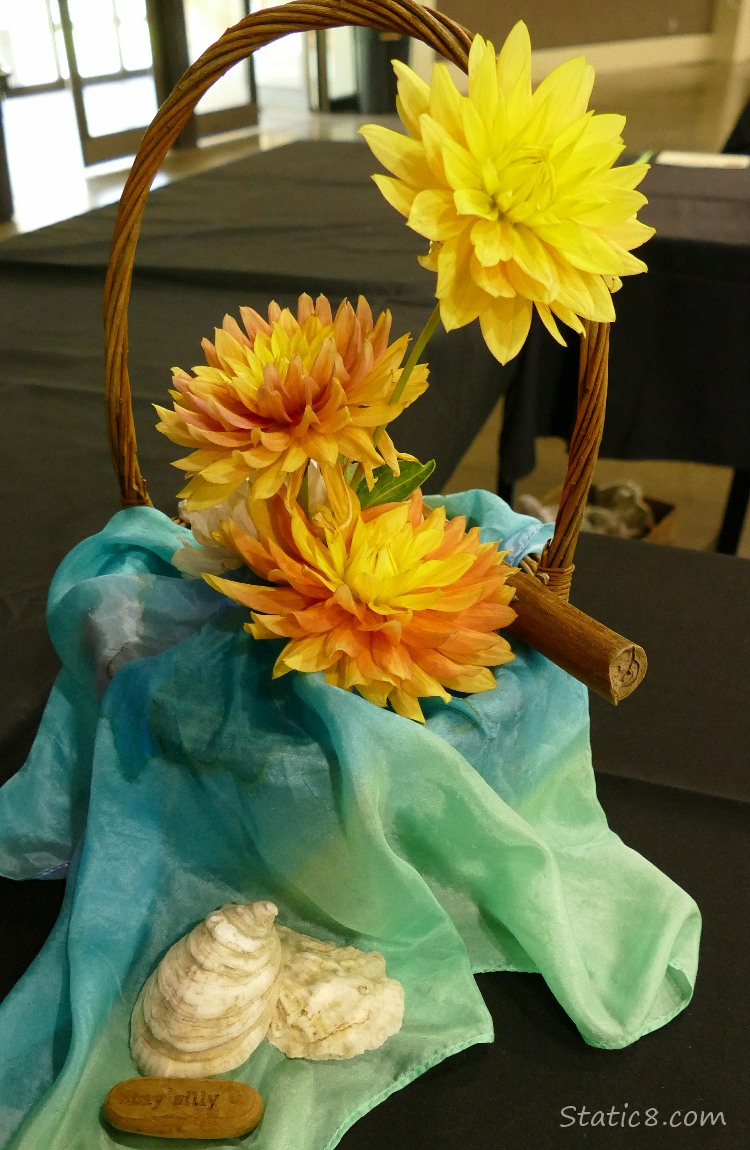 Yellow and Orange Dahlias with a blue fabric and sea shells