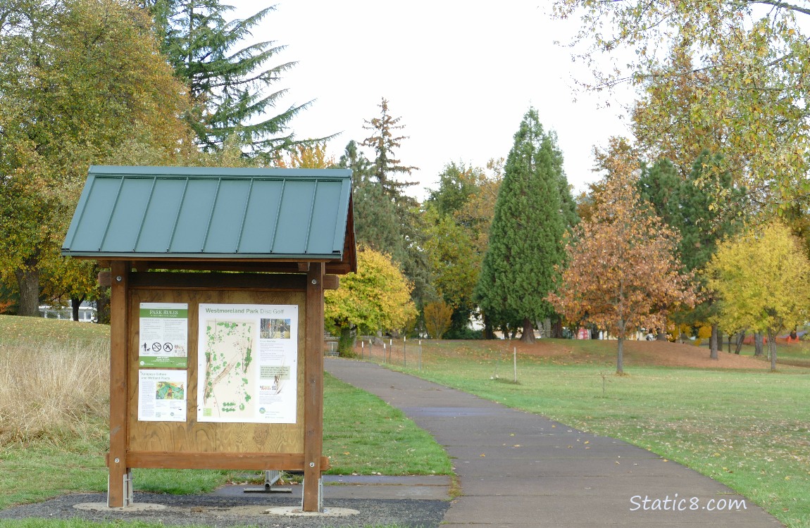 Kiosk next to a paved path, in a park