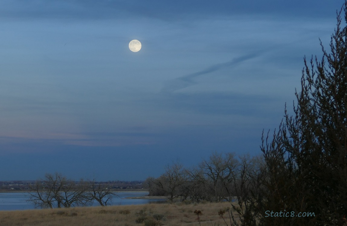 The full moon over the lake, the sky is darkening