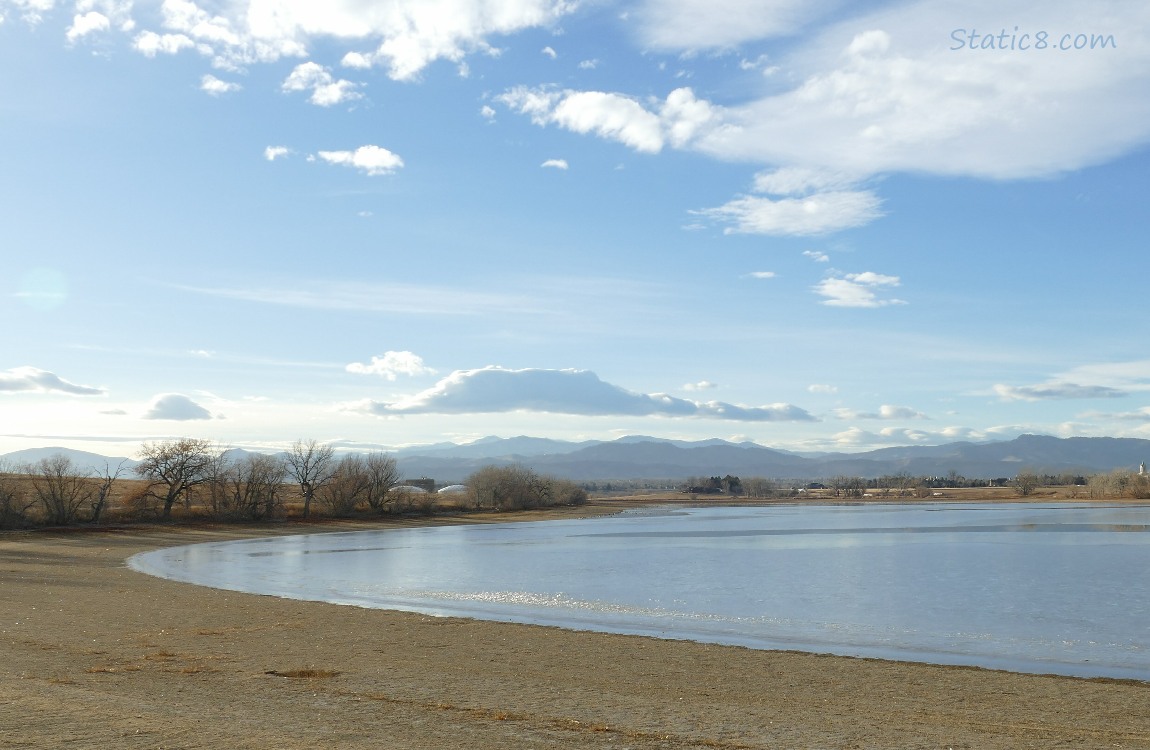 The edge of a lake with mountains in the far distance