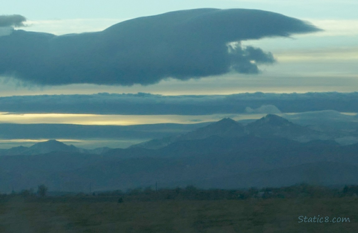 Rocky Mountains and a cloudy and yellow sun set