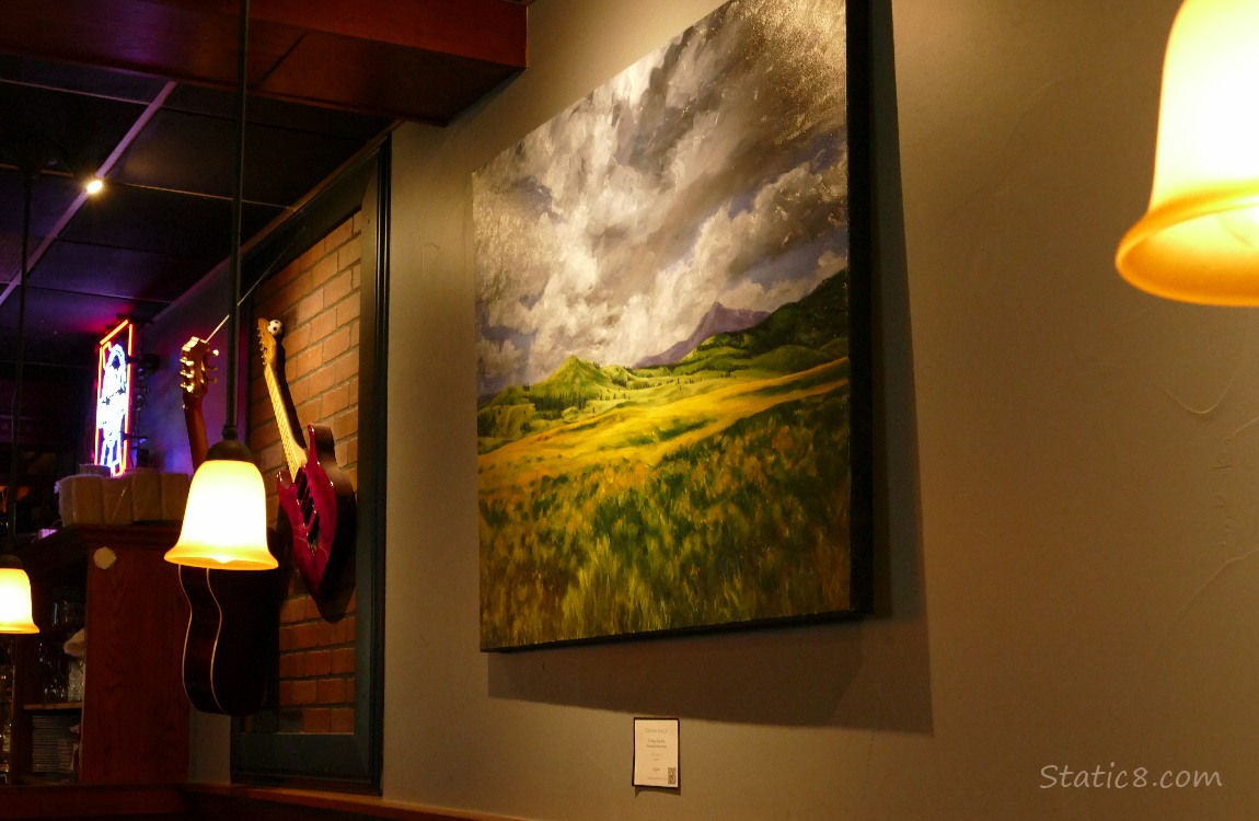 Painting and a guitar hanging on the wall of a restaurant