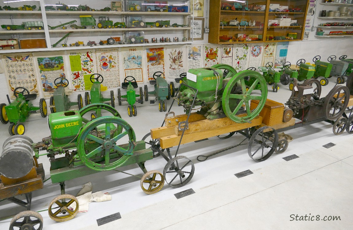 Old John Deere engines in front of toy tractors