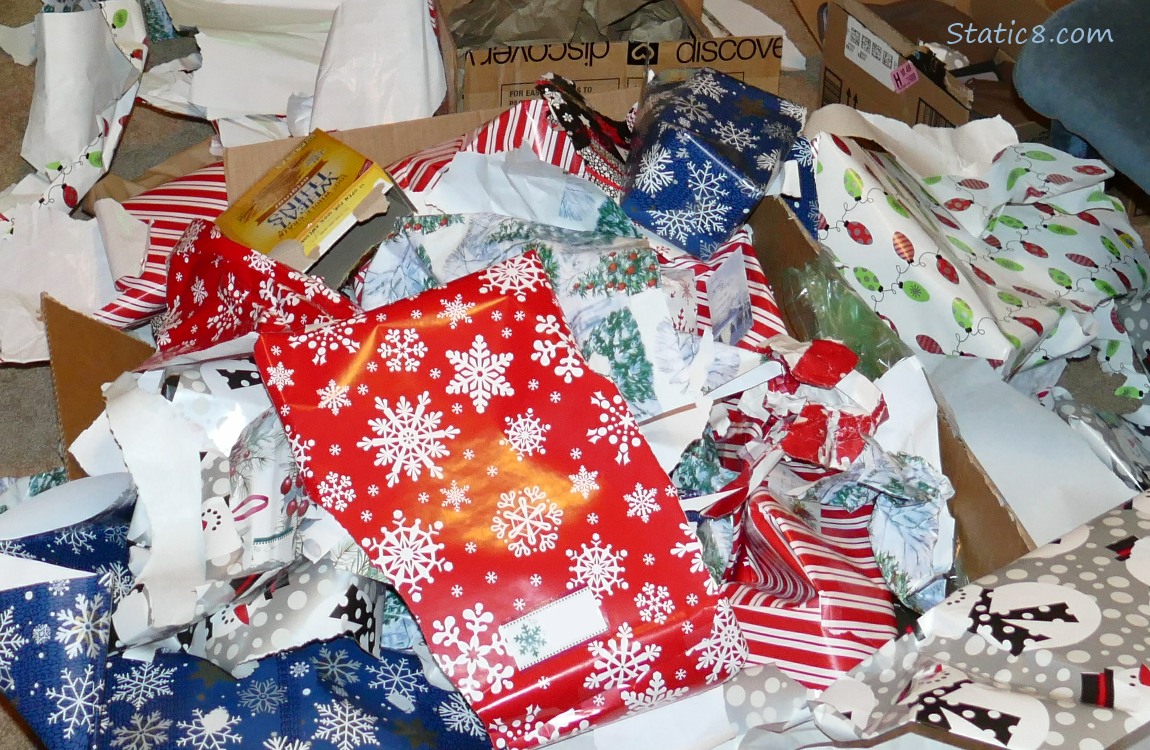 Ripped up christmas wrapping paper, strewn across the floor