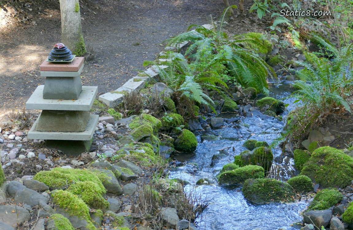 a modern cairn next to the waterfall