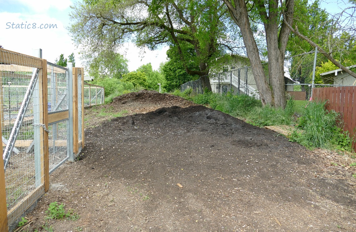 Pile of dirt next to the garden fence