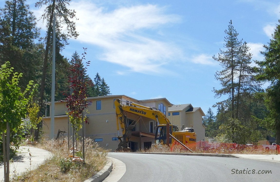 Construction machine in front of a newly built house