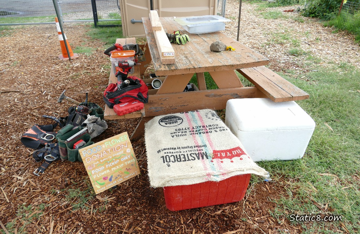 Tools on a wood picnic table with coolers under it
